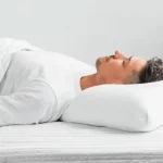 Person in gesunder Rückenlage auf orthopädischem Kissen - die beste Schlafposition für Wirbelsäule und Gehirngesundheit mit korrekter Ausrichtung