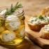 Zelfgemaakte kefir kaas en labneh balletjes geserveerd met verse kruiden en olijfolie