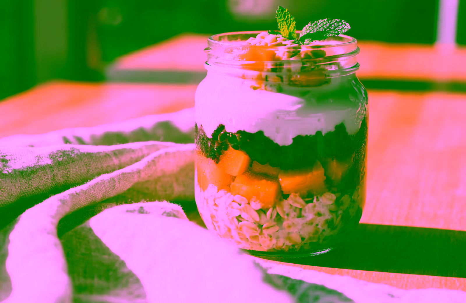 Overnight Oats mit Mango, Beeren und Joghurt geschichtet in einem Glas
